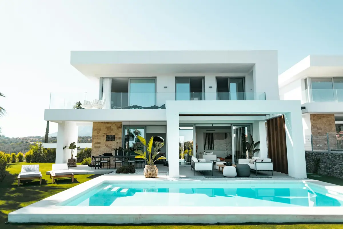 A modern white villa with a pool and garden
