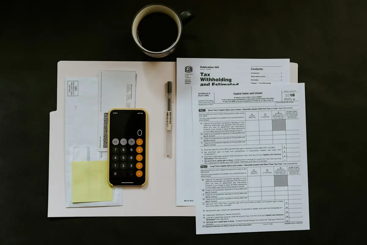 Forms, a calculator and a cup of coffee on a desk