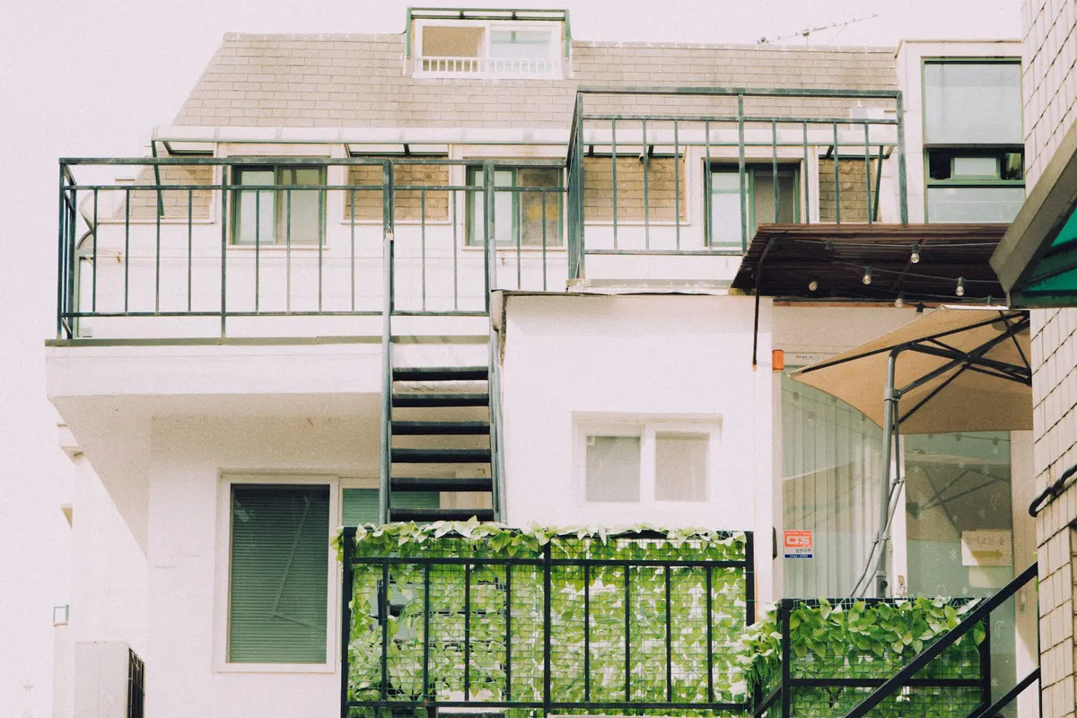 Apartment building with balconies, plants and an outdoor staircase