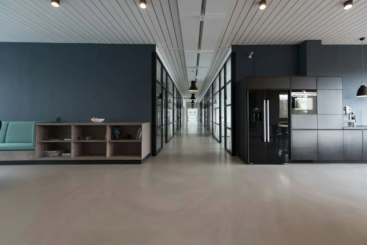 A modern open-plan office with desks and glass walls