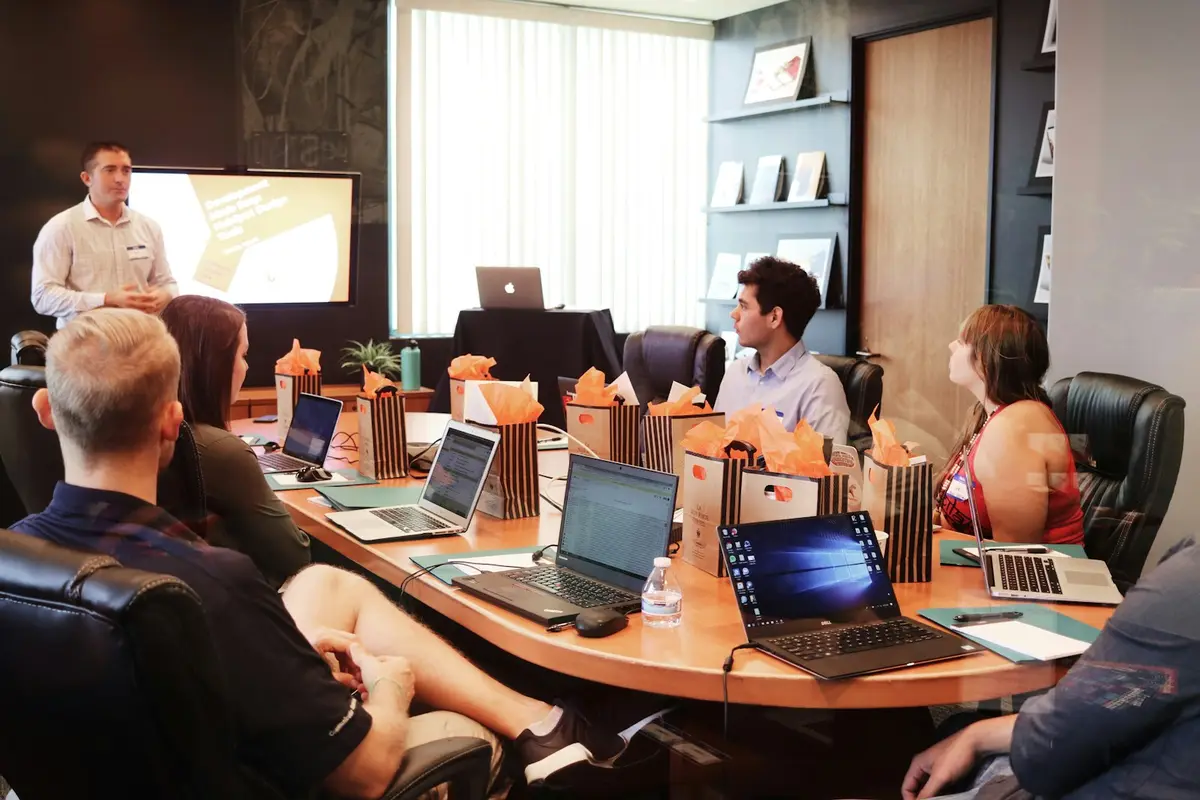 People in a meeting around a table with laptops