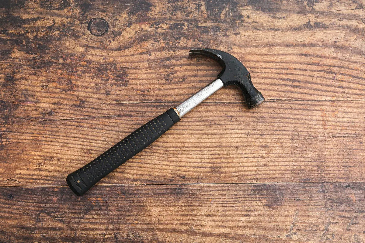 A hammer resting on a wooden table